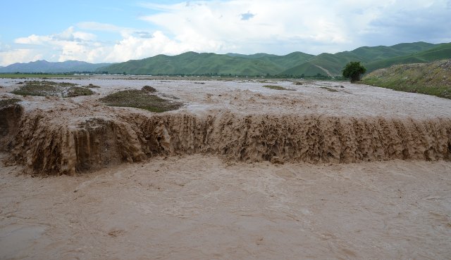 A wide, muddy river overflowing its banks